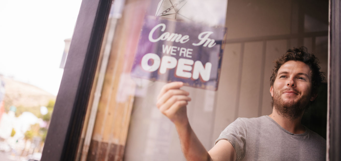 small business owner with open sign